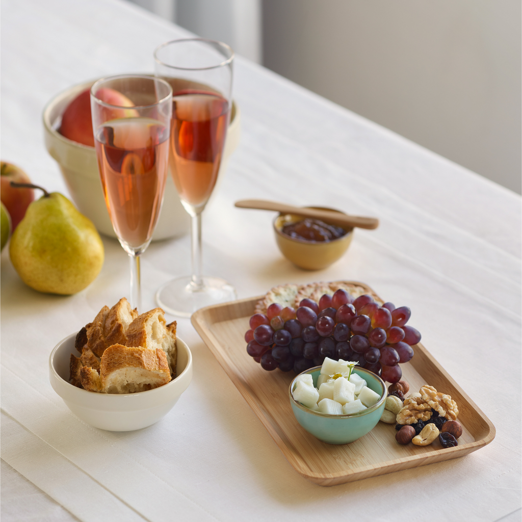 A Bamboo Serving Tray is loaded with grapes and cheese.