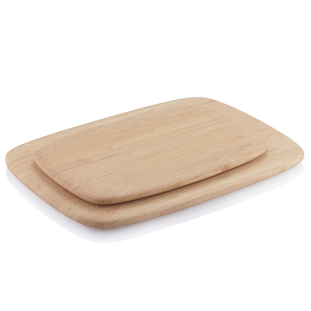 A medium Classic Cutting Board is stacked atop a Large Classic Cutting Board. They are at an angle, which highlights the rounded edges and sleek curves of the boards.