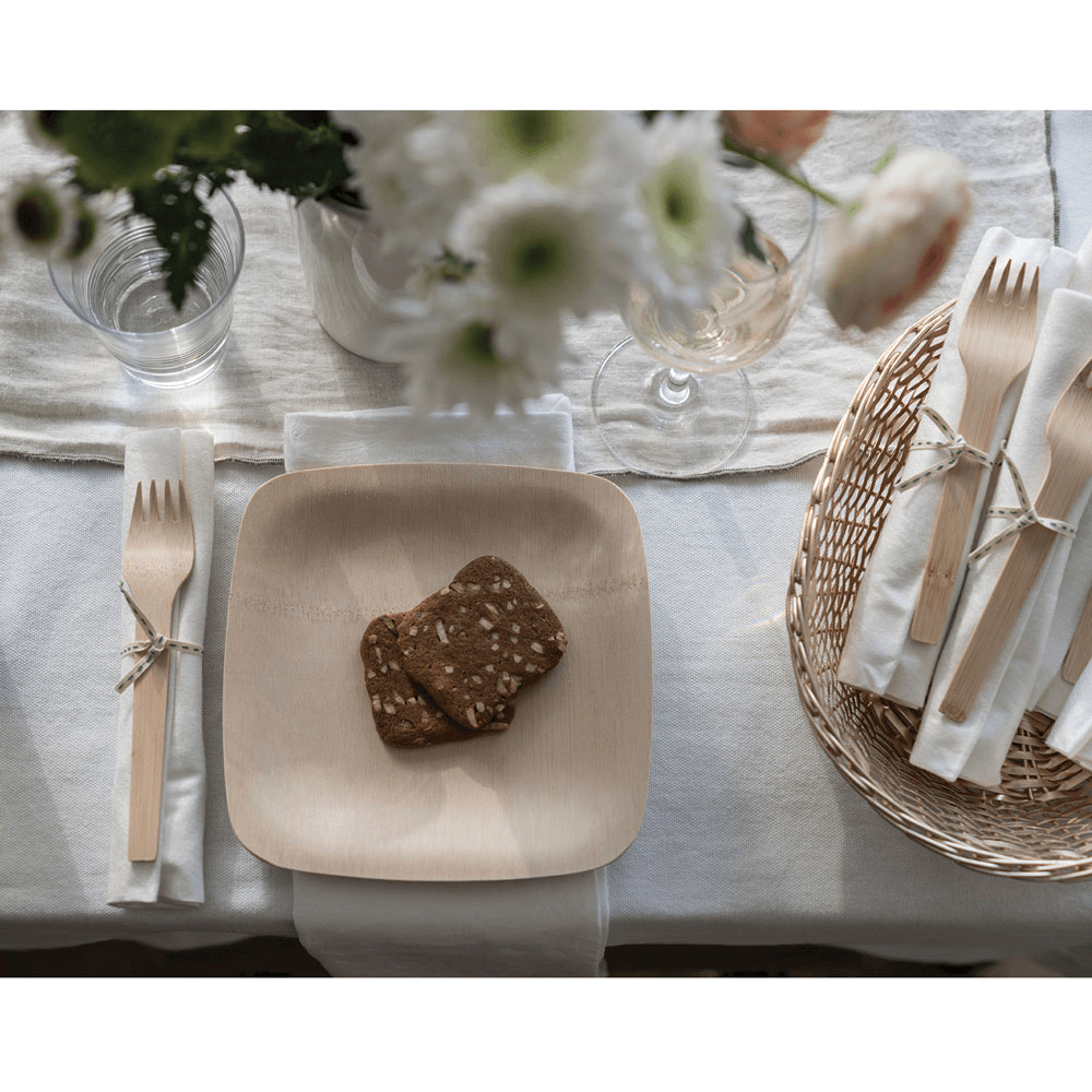 A 7" Veneerware Square plate is on a table. There is a multigrain bread slice on the plate.